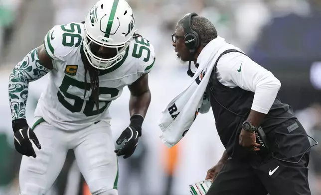 New York Jets head coach Aaron Glenn, right, talks to Jets outside linebacker Demario Davis (56) during an NFL football game against the Green Bay Packers in East Rutherford, N.J., Sunday, Sept. 20, 2026. (AP Photo/Adam Hunger)