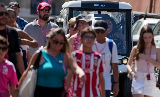 A golf cart makes its way through crowds of tourists in Rome’s historic center, Tuesday, Aug. 18, 2026, amid growing debate over the vehicles’ role in congestion and overtourism. (AP Photo/Gregorio Borgia)