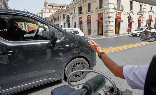 Pascal Duijnhoven, right, argues with a private-hire driver as he drives his golf cart in downtown Rome, Thursday, Aug. 27, 2026, amid growing debate over the vehicles’ role in congestion and overtourism. (AP Photo/Gregorio Borgia)