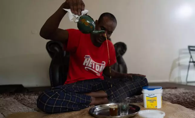 Samba Diallo, a Mauritanian immigrant, makes traditional green tea on the living room floor of his shared apartment in Lockland, Ohio, Friday, July 17, 2026. (AP Photo/Carolyn Kaster)