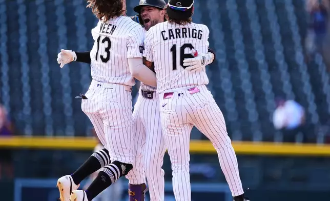 Colorado Rockies' Brett Sullivan, center, is congratulated after his walkoff RBI single by teammates Zac Veen, left, and Cole Carrigg in the 11th inning of a baseball game against the Baltimore Orioles Wednesday, Sept. 2, 2026, in Denver. (AP Photo/David Zalubowski)