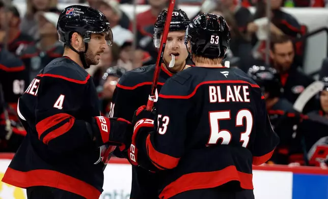 Carolina Hurricanes' Sebastian Aho (20), Jackson Blake (53) and Shayne Gostisbehere (4) talk during the second period of an NHL hockey game against the Florida Panthers in Raleigh, N.C., Tuesday, Sept. 29, 2026. (AP Photo/Karl DeBlaker)