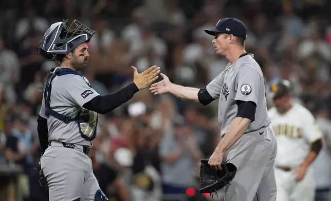 New York Yankees pitcher Tim Hill, right, celebrates with catcher Austin Wells after the Yankees defeated the San Diego Padres 5-1 in a baseball game Saturday, Sept. 5, 2026, in San Diego. (AP Photo/Gregory Bull)
