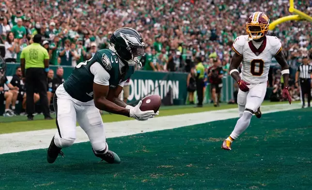 Philadelphia Eagles wide receiver Dontayvion Wicks (13) catches a pass for a touchdown in front of Washington Commanders cornerback Mike Sainristil (0) during the first half of an NFL football game, Sunday, Sept. 13, 2026, in Philadelphia. (AP Photo/Matt Slocum)