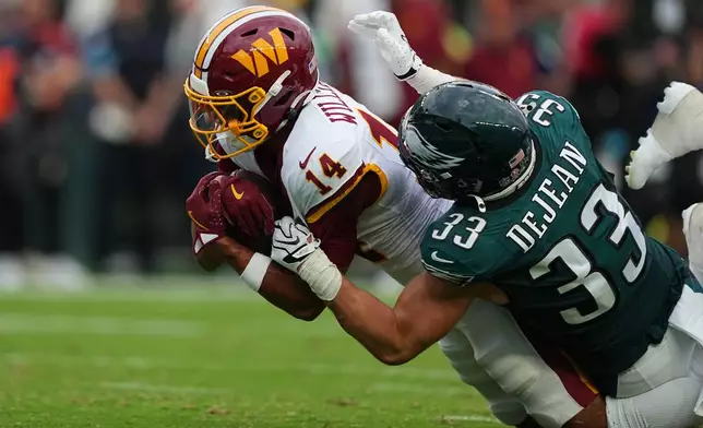 Washington Commanders wide receiver Antonio Williams (14) is stopped by Philadelphia Eagles cornerback Cooper DeJean (33) during the first half of an NFL football game, Sunday, Sept. 13, 2026, in Philadelphia. (AP Photo/Matt Rourke)
