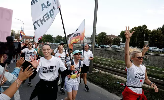 People welcome a group of university students at the end of their cycling tour of the Balkan country ahead of an early election next month challenging populist President Aleksandar Vucic, in Kragujevac, Serbia, Saturday, Sept. 26, 2026. (AP Photo/Marko Drobnjakovic)