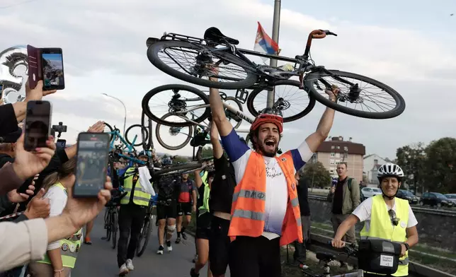 People welcome a group of university students at the end of their cycling tour of the Balkan country ahead of an early election next month challenging populist President Aleksandar Vucic, in Kragujevac, Serbia, Saturday, Sept. 26, 2026. (AP Photo/Marko Drobnjakovic)