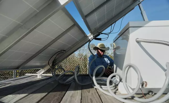 Neal Flanagan, a research scientist at Duke University, works near a solar panel powering a sensor that measures carbon emissions Wednesday, May 6, 2026, in Belhaven, N.C. (AP Photo/Joshua A. Bickel)