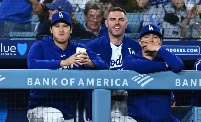 Los Angeles Dodgers' Shohei Ohtani, left, looks on during the ninth inning of a baseball game against the Washington Nationals, Friday, Sept. 4, 2026, in Los Angeles. (AP Photo/William Liang)