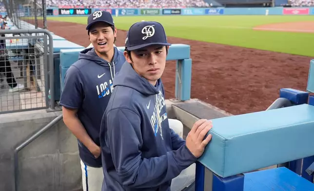 Los Angeles Dodgers' Shohei Ohtani, left, and Roki Sasaki stand in the dugout during the first inning of a baseball game against the Washington Nationals, Saturday, Sept. 5, 2026, in Los Angeles. (AP Photo/Mark J. Terrill)