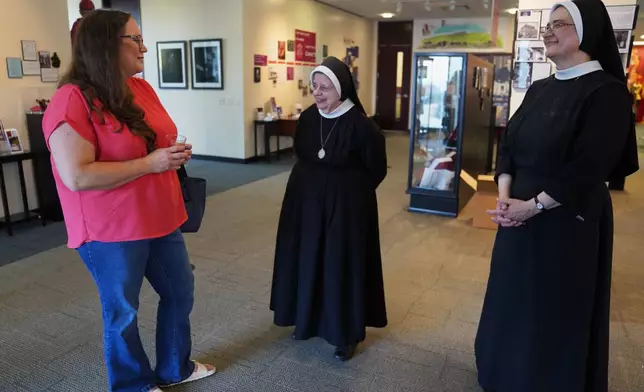 Bonnie Engstrom talks with two sisters at the Archbishop Fulton Sheen Museum in Peoria, Ill., on July 16, 2026. (AP Photo/Jessie Wardarski)