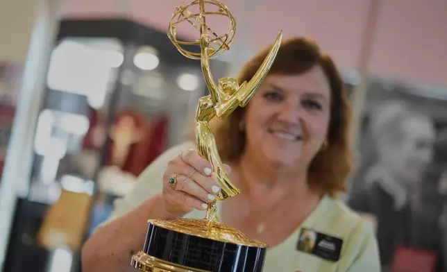 The Archbishop Fulton Sheen Museum tour coordinator, Rhonda Bachman, holds an Emmy award won by the late Archbishop Fulton Sheen, in Peoria, Ill., on July 15, 2026. (AP Photo/Jessie Wardarski)