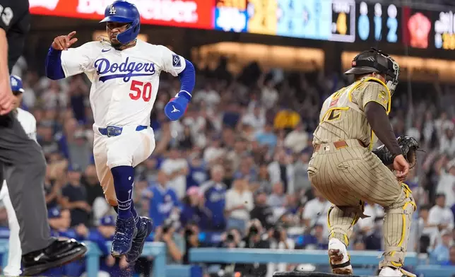 Los Angeles Dodgers' Mookie Betts, left, scores on a single by Freddie Freeman as San Diego Padres catcher Luis Campusano takes a late throw during the fifth inning of a baseball game Tuesday, Sept. 22, 2026, in Los Angeles. (AP Photo/Mark J. Terrill)