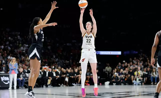 Indiana Fever guard Caitlin Clark (22) goes up to shoot a 3-point basket against Las Vegas Aces forward Brianna Turner, front left, during the first half in Game 1 of an WNBA basketball first-round playoff series Sunday, Sept. 27, 2026, in Las Vegas. (AP Photo/Steve Marcus)