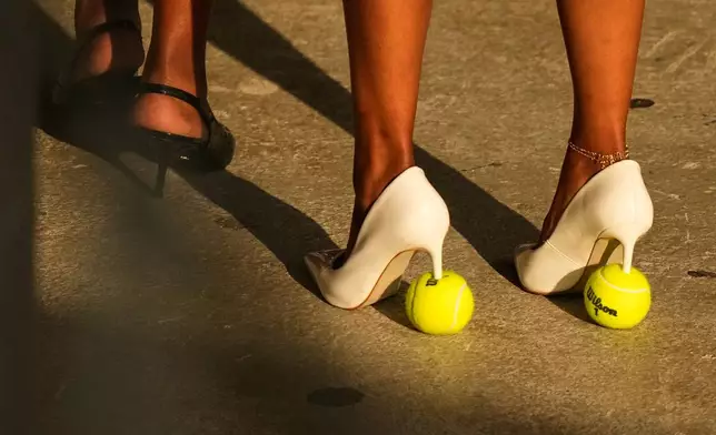 A woman wears tennis ball high heeled shoes during a match between Aryna Sabalenka, of Belarus, and Elena Rybakina, of Kazakhstan, during the women's singles final of the U.S. Open tennis championships Saturday, Sept. 12, 2026, in New York. (AP Photo/Frank Franklin II)