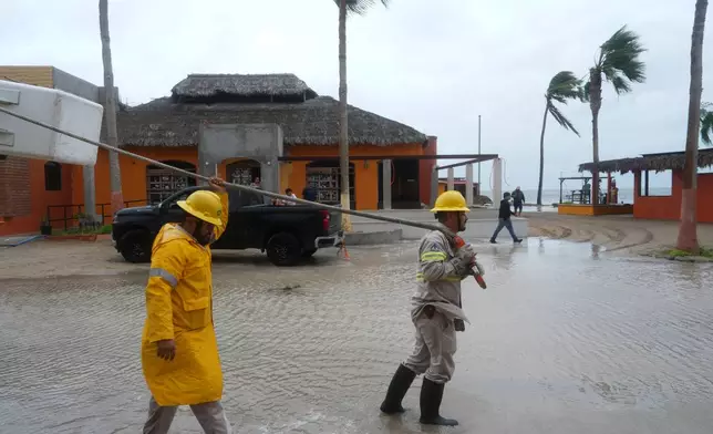 Workers pull a boat to shore as Hurricane Polo approaches Puerto San Carlos, Baja California Sur state, Mexico, Monday, Sept. 28, 2026. (AP Photo/Eduardo Verdugo)