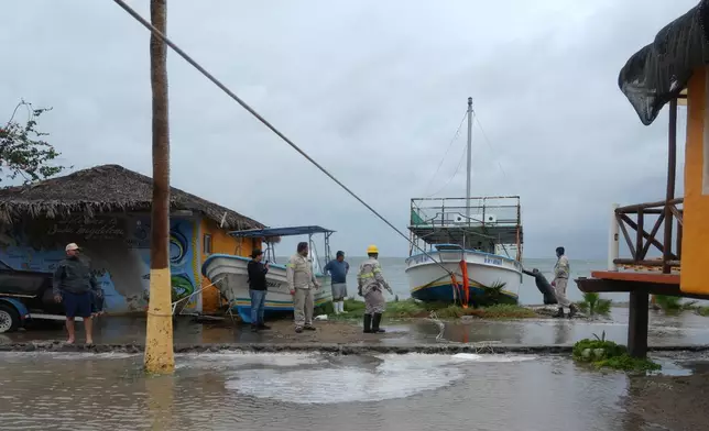 Workers pull a boat to shore as Hurricane Polo approaches Puerto San Carlos, Baja California Sur state, Mexico, Monday, Sept. 28, 2026. (AP Photo/Eduardo Verdugo)