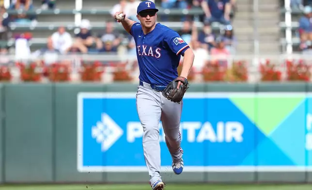 Texas Rangers shortstop Corey Seager throws to first base to get out Minnesota Twins' Austin Martin during the second inning of a baseball game, Sunday, Sept. 27, 2026, in Minneapolis. (AP Photo/Matt Krohn)