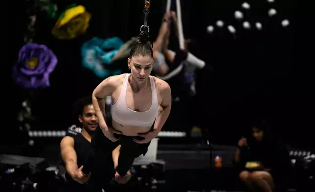 Performer Megan Nielsen, suspended by her hair, rehearses at The Cirk, a professional circus company in Johannesburg, Thursday, Aug. 27, 2026. (AP Photo/Themba Hadebe)