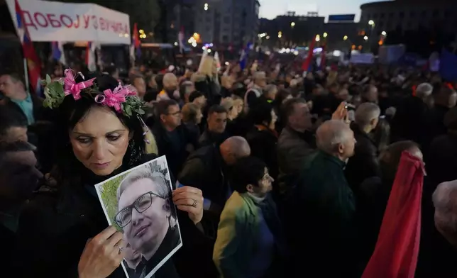 FILE - A supporter of Serbia's President Aleksandar Vucic holds his photo during a rally in Belgrade, Serbia, April 12, 2025. (AP Photo/Darko Vojinovic, File)