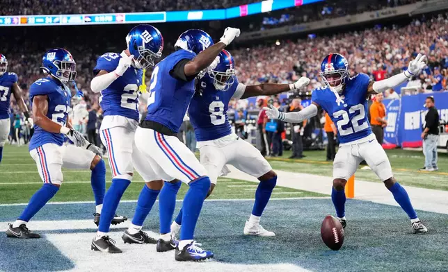 New York Giants players, from left, Tyler Nubin, Greg Newsome II, Deonte Banks, Jevon Holland and Andru Phillips celebrate an interception by Holland on a pass by Dallas Cowboys quarterback Dak Prescott during the first half of an NFL football game Sunday, Sept. 13, 2026, in East Rutherford, N.J. (AP Photo/Yuki Iwamura)