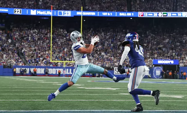 Dallas Cowboys tight end Jake Ferguson, left, makes a catch in front of New York Giants middle linebacker Tremaine Edmunds during the second half of an NFL football game Sunday, Sept. 13, 2026, in East Rutherford, N.J. (AP Photo/Pamela Smith)