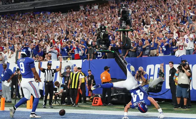 New York Giants running back Cam Skattebo does a flip while celebrating a touchdown against the Dallas Cowboys during the first half of an NFL football game Sunday, Sept. 13, 2026, in East Rutherford, N.J. (AP Photo/Pamela Smith)