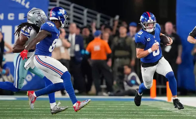 New York Giants quarterback Jaxson Dart, right, runs for yardage against the Dallas Cowboys during the first half of an NFL football game Sunday, Sept. 13, 2026, in East Rutherford, N.J. (AP Photo/Yuki Iwamura)