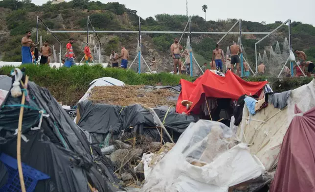 Migrants take a shower near their tents at El Trampolín beach in the Spanish exclave of Ceuta, Wednesday, Sept. 2, 2026. (AP Photo/Francis González)