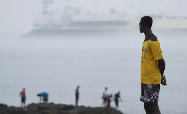 Migrants stand at El Trampolín beach in the Spanish exclave of Ceuta, Wednesday, Sept. 2, 2026. (AP Photo/Francis González)