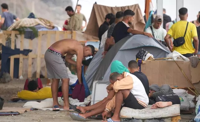 Migrants stand near their tents at El Trampolín beach in the Spanish exclave of Ceuta, Wednesday, Sept. 2, 2026. (AP Photo/Francis González)