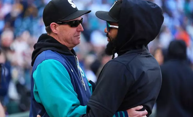 Seattle Mariners manager Dan Wilson, left, greets shortstop J.P. Crawford, right, after a win over the Los Angeles Angels in a baseball game, Sunday, Sept. 27, 2026, in Seattle. (AP Photo/Lindsey Wasson)