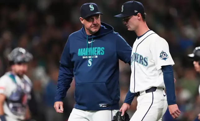 Seattle Mariners starting pitcher Kade Anderson, right, leaves the game with manager Dan Wilson, left, after being hit by a line drive single by Los Angeles Angels' Christian Moore during the fourth inning of a baseball game, Saturday, Sept. 26, 2026, in Seattle. (AP Photo/Lindsey Wasson)