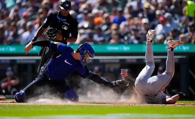 Minnesota Twins' Luke Keaschall, right, scores ahead of the tag of Detroit Tigers catcher Dillon Dingler, left, during the first inning of a baseball game Monday, Sept. 7, 2026, in Detroit. (AP Photo/Paul Sancya)