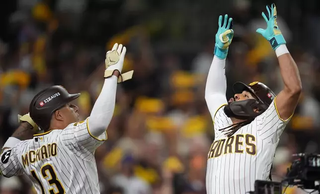 San Diego Padres right fielder Fernando Tatis Jr. and third baseman Manny Machado (13) celebrate their back-to-back home runs in the first inning of Game 1 of the National League Wild Card baseball playoff series against the Chicago Cubs Tuesday, Sept. 29, 2026, in San Diego. (AP Photo/Gregory Bull)
