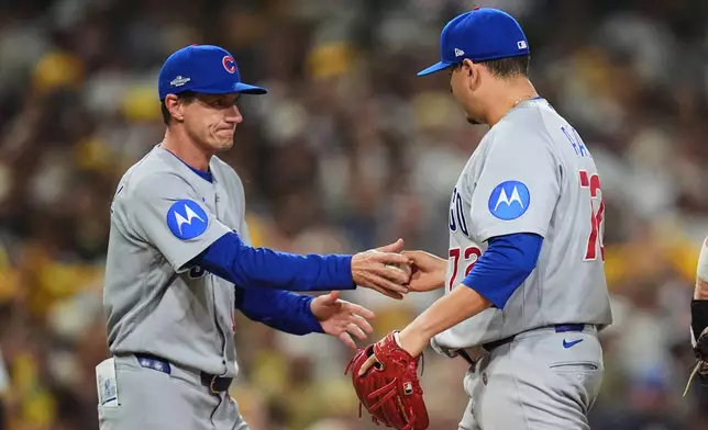 Chicago Cubs pitcher Javier Assad (72) hands the ball to manager Craig Counsell as he is pulled in the fifth inning against the San Diego Padres in Game 1 of the National League Wild Card baseball playoff series Tuesday, Sept. 29, 2026, in San Diego. (AP Photo/Gregory Bull)