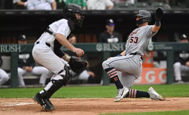 Detroit Tigers' Ben Malgeri (53) slides safely into home plate on a Kevin McGonigle sacrifice fly as Chicago White Sox catcher Kyle Teel, left, waits for the throw during the fifth inning of a baseball game Saturday, Sept. 19, 2026, in Chicago. (AP Photo/Paul Beaty)