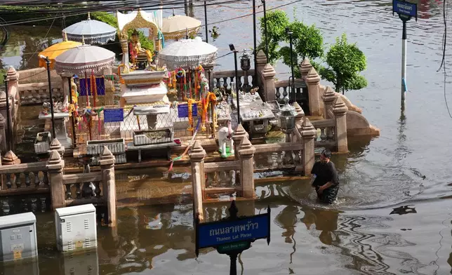 A man wades through floodwaters after heavy rain in Bangkok, Thailand, Tuesday, Sept. 29, 2026. (AP Photo/Sakchai Lalit)