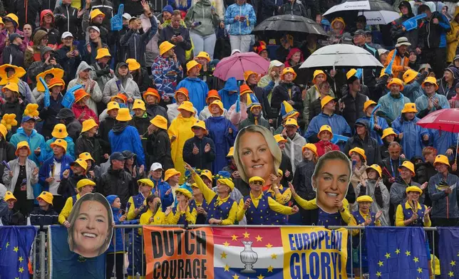 Spectators gather in the rain on the 1st tee on the final day of the Solheim Cup in Den Bosch, Netherlands, Sunday, Sept. 13, 2026. (AP Photo/Alastair Grant)
