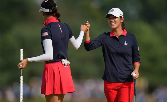 Andrea Lee, right, bumps fists with Yealimi Noh of the United States after holing a putt on the 9th green during the Solheim Cup in Den Bosch, Netherlands, Saturday, Sept. 12, 2026. (AP Photo/Alastair Grant)