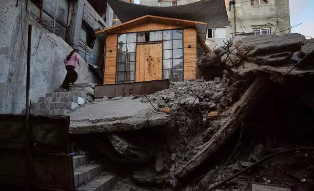 Palestinian youth Julia Joudeh, 11, climbs to her new wooden house, which was built on top of the rubble of her family's home destroyed during the war between Israel and Hamas, in Gaza City, Wednesday, Sept. 2, 2026. (AP Photo/Abdel Kareem Hana)