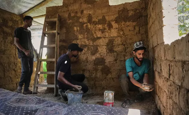 Young Palestinians build a room with mud bricks as an alternative amid a shortage of construction supplies in the Gaza Strip, in Nuseirat, Saturday, Sept. 5, 2026. (AP Photo/Abdel Kareem Hana)