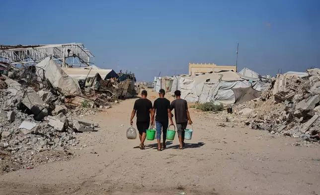 Palestinians carry water to make clay bricks for building a house amid a shortage of construction materials in the Gaza Strip, in the Maghazi refugee camp, central Gaza Strip, Thursday, Sept. 3, 2026. (AP Photo/Abdel Kareem Hana)