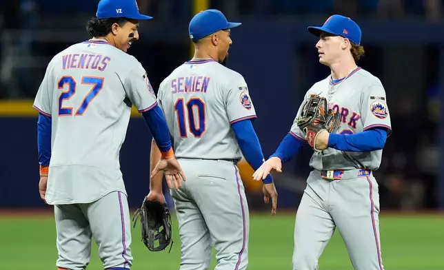 New York Mets right fielder Carson Benge celebrates with second baseman Marcus Semien (10) and Mark Vientos (27) after the team defeated the Tampa Bay Rays during a baseball game Monday, Aug. 31, 2026, in St. Petersburg, Fla. (AP Photo/Chris O'Meara)