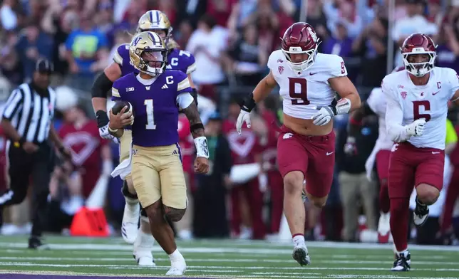 Washington quarterback Demond Williams Jr. (1) rushes against Washington State, including defensive end Matyus McLain (9) during the second half of an NCAA college football game, Sunday, Sept. 6, 2026, in Seattle. (AP Photo/Lindsey Wasson)