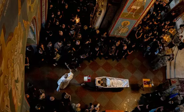 Relatives and friends mourn near the coffin of Ukrainian serviceman Danyil Smyrnov, 21, who was killed on the frontline, during the funeral ceremony in Kyiv, Ukraine, Thursday, Sept. 3, 2026. (AP Photo/Alex Babenko)