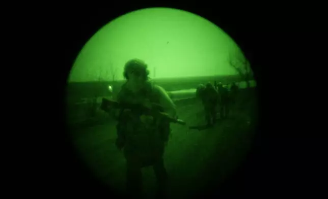In this March 20, 2024 photo made through night vision goggles, Ukrainian serviceman Danyil Smyrnov participates in an infantry mission in Umanske, Adviivka direction, Ukraine. (AP Photo/Alex Babenko)