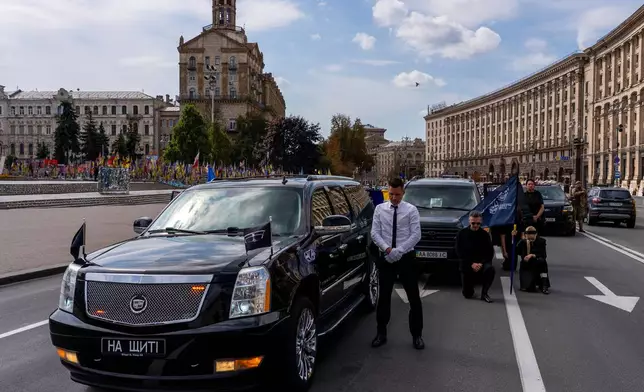 Family and friends pay their respect to soldier Danyil Smyrnov, 21, who was killed on the frontline, during the minute of silence on Independence Square, Kyiv, Ukraine, Thursday, Sept. 3, 2026. (AP Photo/Alex Babenko)