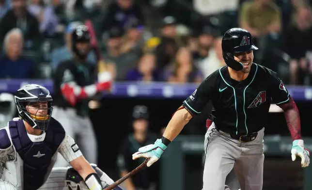Arizona Diamondbacks' Corbin Carroll, right, breaks from the batter's box after connecting for a triple to drive in two runs as Colorado Rockies catcher Hunter Goodman looks on in the first inning of a baseball game Wednesday, Sept. 23, 2026, in Denver. (AP Photo/David Zalubowski)