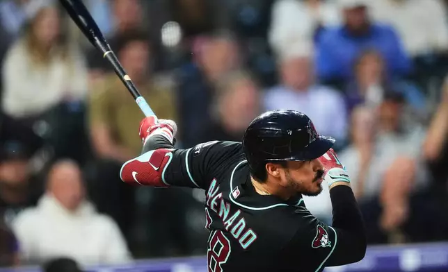 Arizona Diamondbacks' Nolan Arenado watches his RBI single off Colorado Rockies starting pitcher Mason Adams in the first inning of a baseball game Wednesday, Sept. 23, 2026, in Denver. (AP Photo/David Zalubowski)